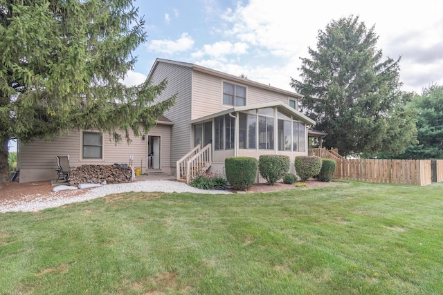 back of property with a lawn and a sunroom