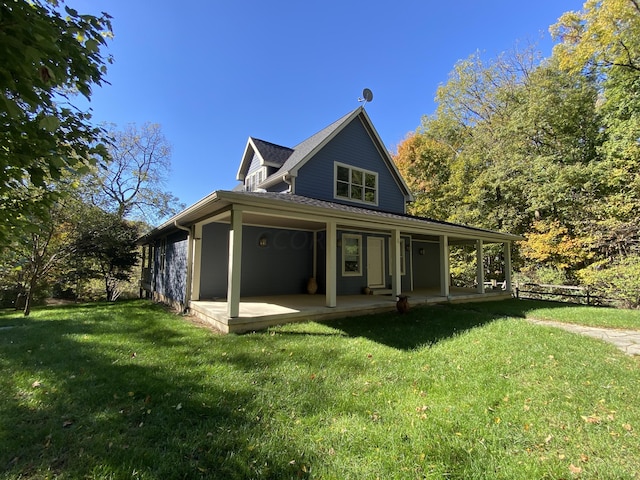 rear view of house featuring a lawn and a porch