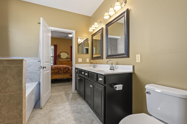 bathroom featuring vanity, a bath, tile walls, tile patterned flooring, and toilet