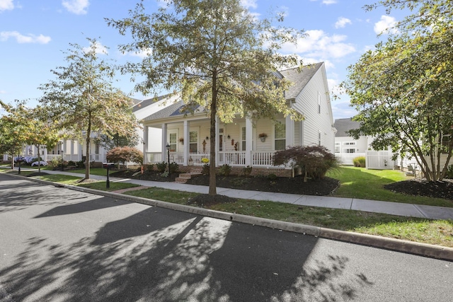 view of front of house with covered porch and a front yard