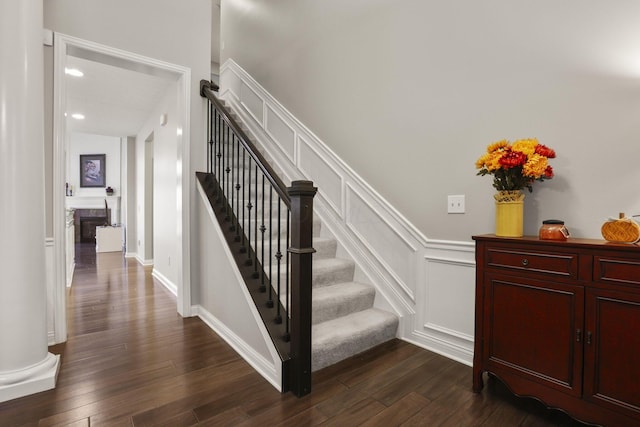 staircase featuring hardwood / wood-style flooring and ornate columns