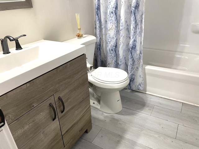 full bathroom with toilet, vanity, and shower / tub combo