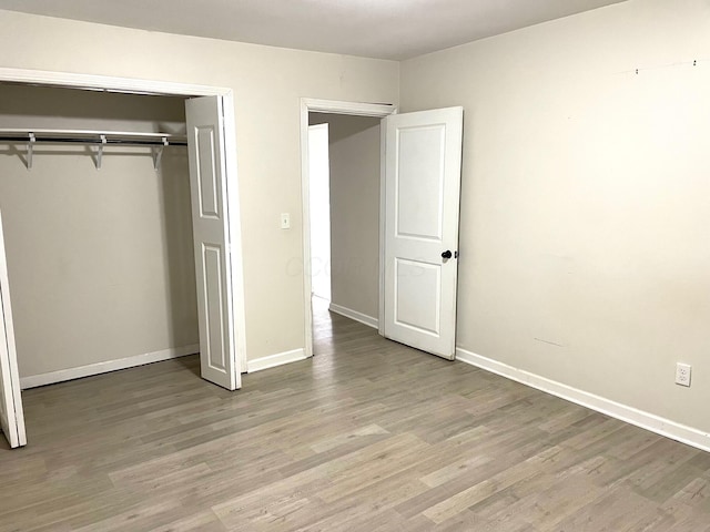 unfurnished bedroom featuring light wood-type flooring and a closet