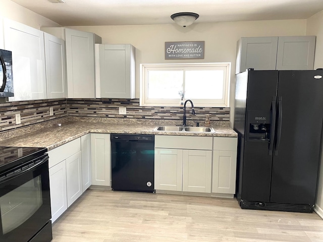 kitchen featuring white cabinetry, sink, decorative backsplash, and black appliances