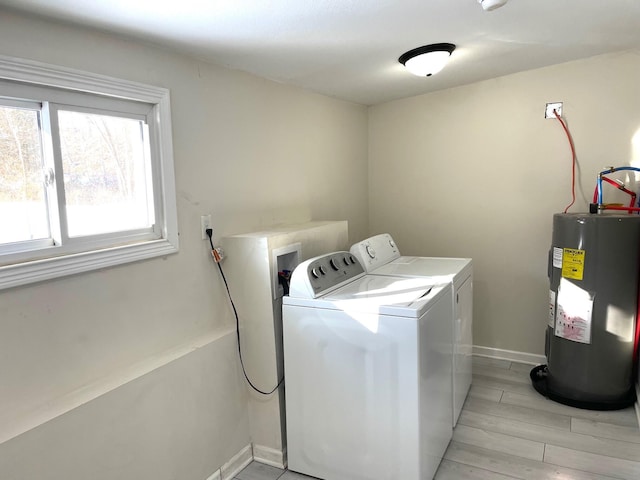 laundry area with electric water heater, light wood-type flooring, and independent washer and dryer