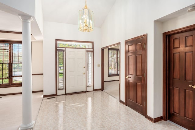 foyer with an inviting chandelier and decorative columns