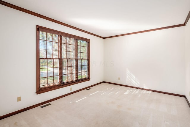 carpeted spare room featuring crown molding