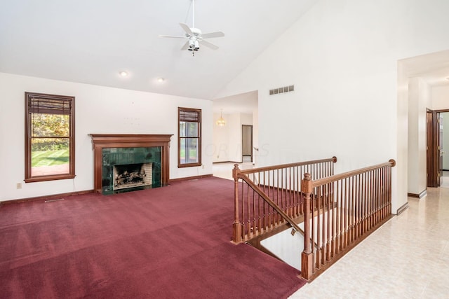 living room featuring a high end fireplace, high vaulted ceiling, and ceiling fan