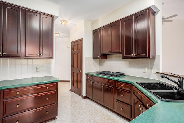 kitchen featuring backsplash, ceiling fan, sink, and stainless steel gas cooktop