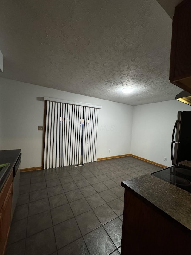 kitchen featuring tile patterned floors, dishwasher, black fridge, and a textured ceiling