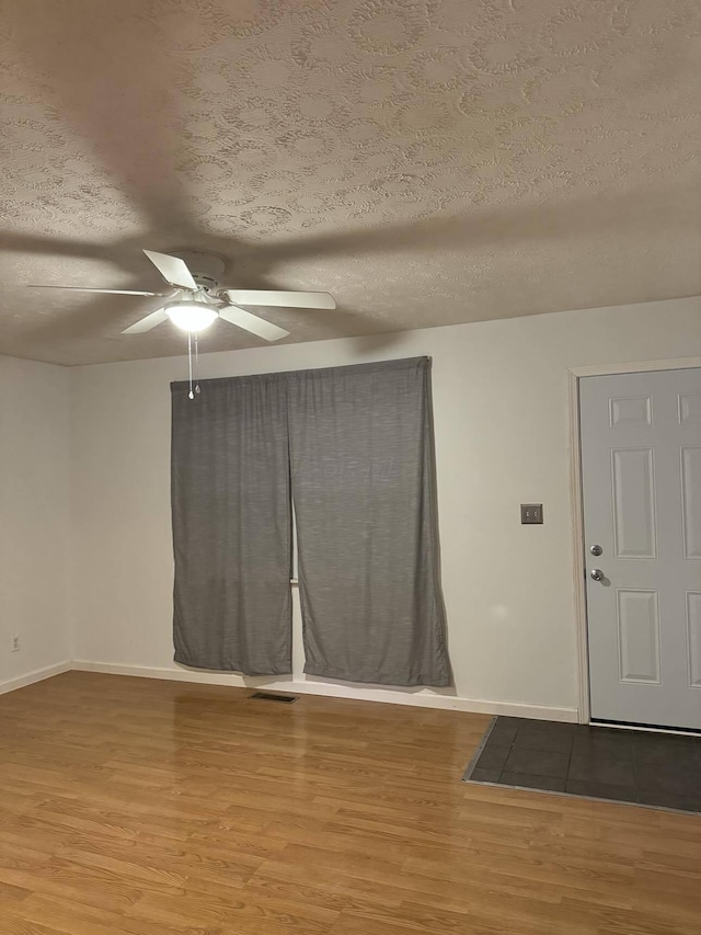 unfurnished room featuring a textured ceiling and hardwood / wood-style flooring