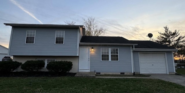 tri-level home with a lawn and a garage