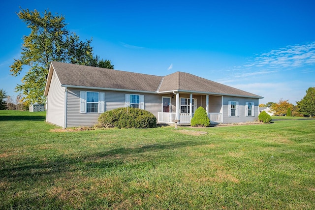 ranch-style home featuring covered porch and a front lawn