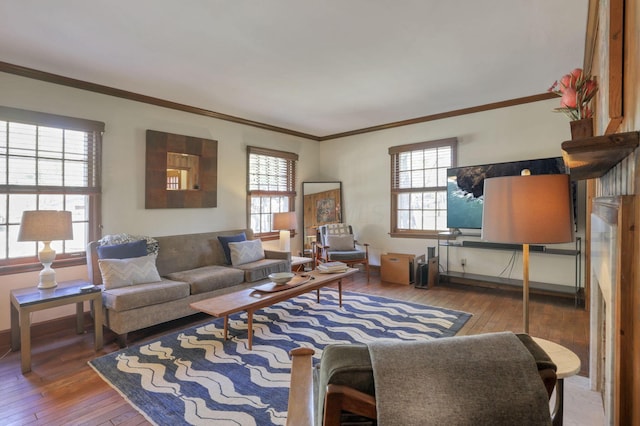 living room with wood-type flooring, plenty of natural light, and ornamental molding