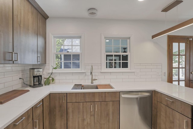 kitchen featuring decorative backsplash, dishwasher, and sink