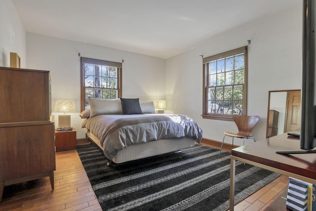 bedroom with multiple windows and hardwood / wood-style floors