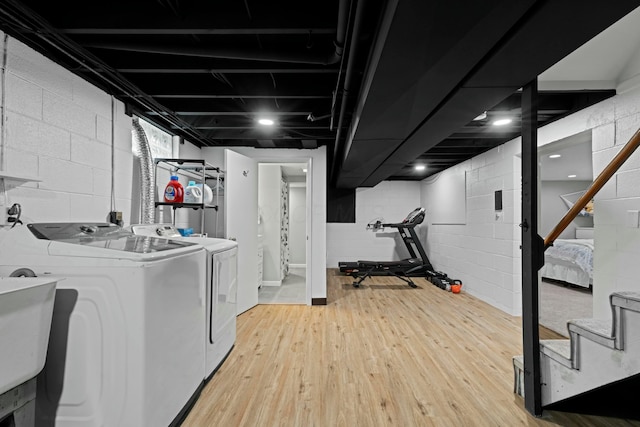 clothes washing area featuring light wood finished floors, washing machine and dryer, and laundry area