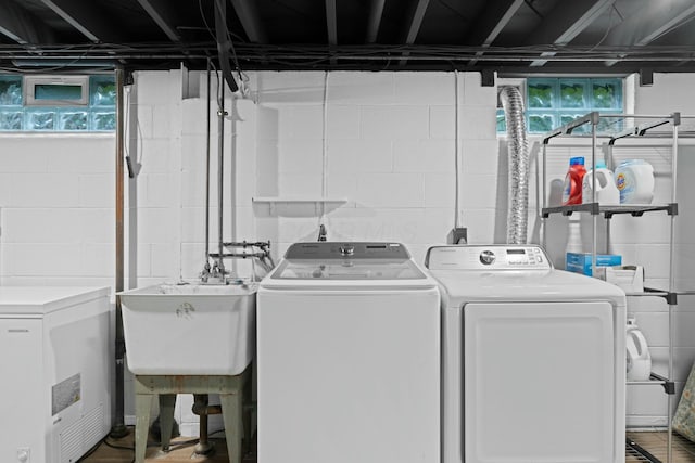 laundry room featuring washer and clothes dryer, laundry area, and a sink
