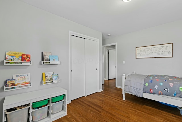 bedroom featuring a closet, baseboards, and wood finished floors