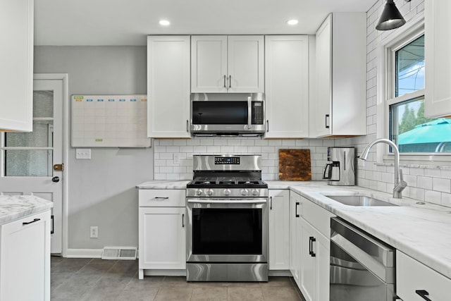 kitchen with a sink, white cabinets, and stainless steel appliances