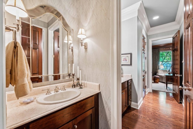 bathroom featuring vanity, hardwood / wood-style flooring, and ornamental molding