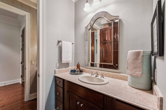 bathroom with hardwood / wood-style floors, vanity, and ornamental molding