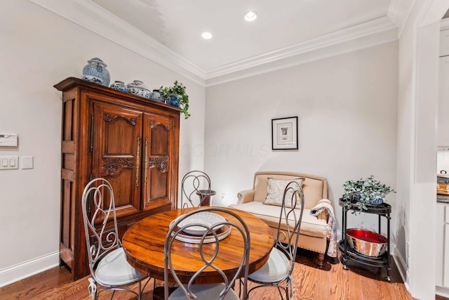 dining area featuring wood-type flooring and ornamental molding