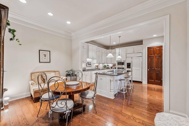 dining area featuring hardwood / wood-style flooring and ornamental molding