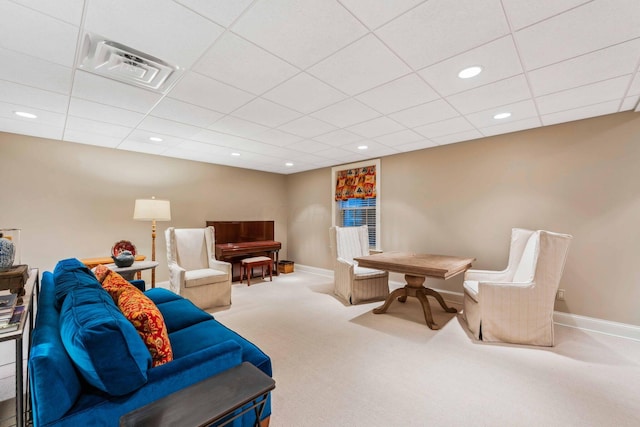 carpeted living room with a drop ceiling