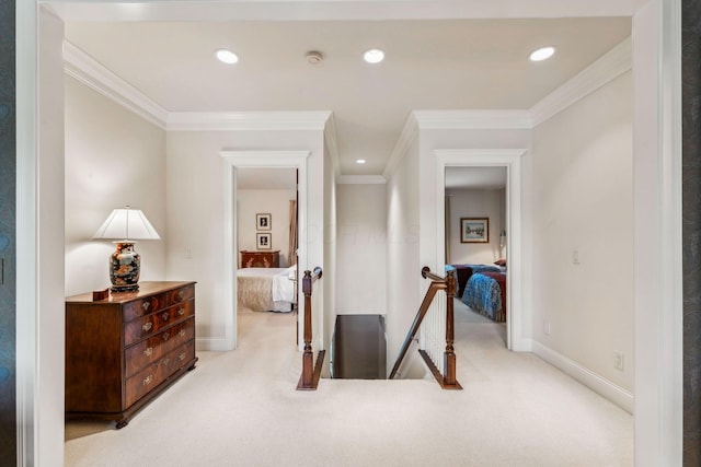 hall with light colored carpet and ornamental molding