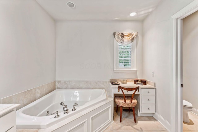 bathroom with tile patterned flooring, vanity, toilet, and a tub to relax in