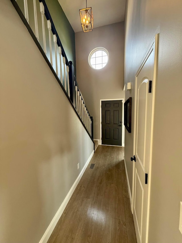 foyer with dark hardwood / wood-style flooring, a high ceiling, and an inviting chandelier