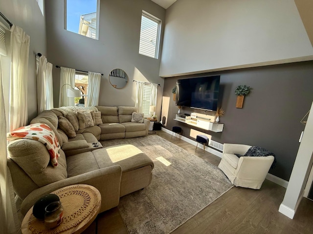 living room featuring wood-type flooring and a high ceiling