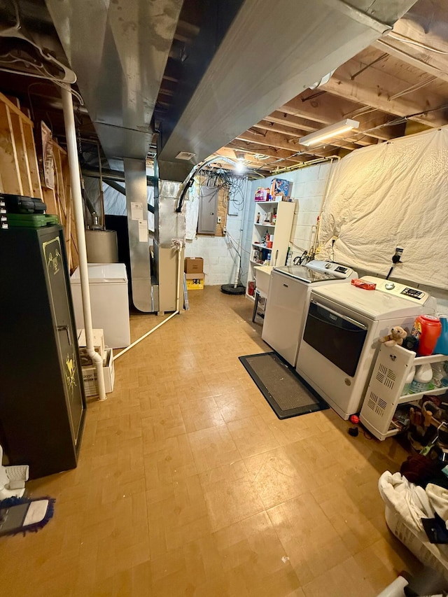 basement with independent washer and dryer, electric panel, heating unit, and fridge