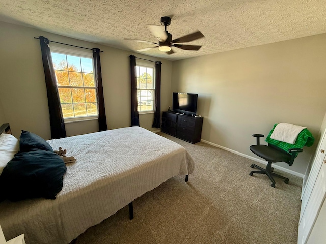 bedroom with carpet flooring, ceiling fan, and a textured ceiling