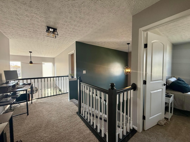 corridor with carpet floors and a textured ceiling