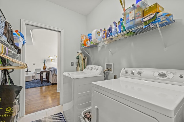 clothes washing area with light tile patterned floors and washing machine and clothes dryer