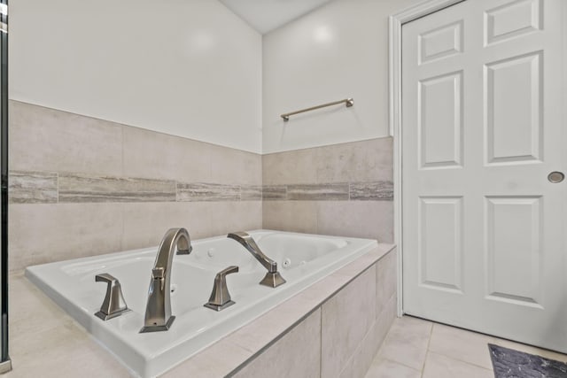 bathroom with tile patterned flooring and tiled tub