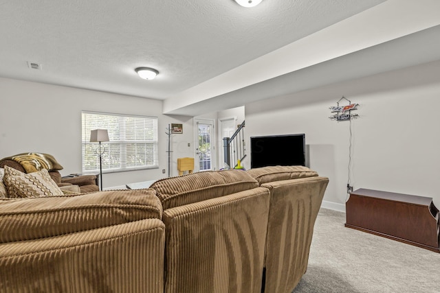 carpeted living room featuring a textured ceiling