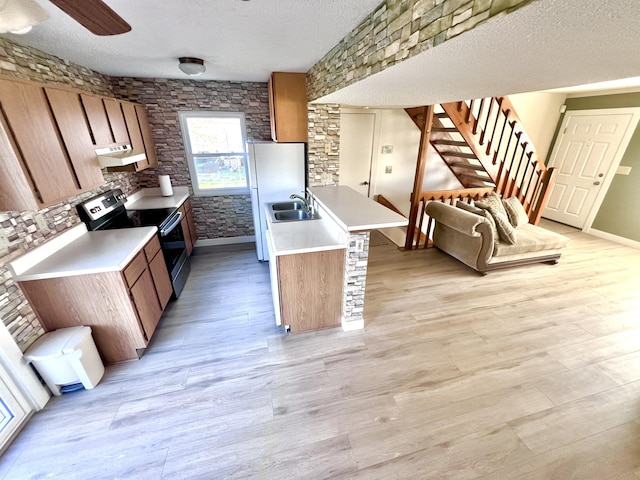 kitchen featuring stainless steel electric stove, sink, light hardwood / wood-style flooring, a textured ceiling, and white fridge