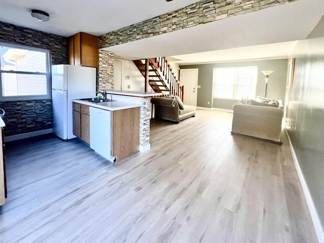 kitchen with light hardwood / wood-style flooring, white dishwasher, a textured ceiling, and sink