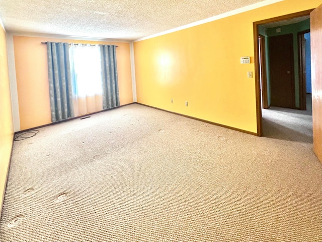 empty room with crown molding, carpet floors, and a textured ceiling