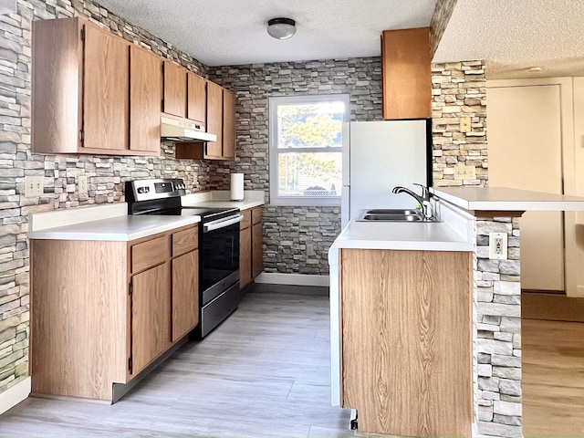 kitchen with electric range, light hardwood / wood-style floors, and a textured ceiling