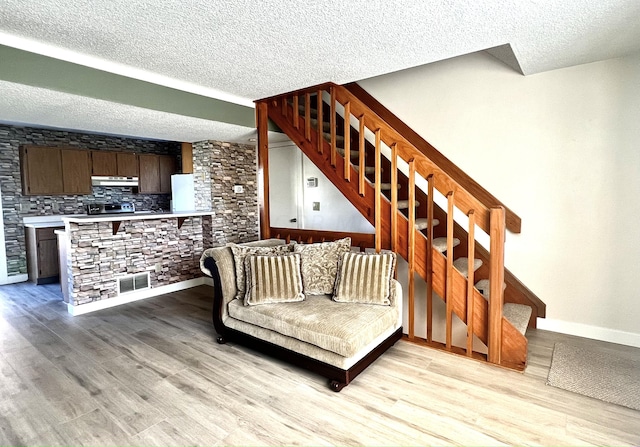 living room featuring a textured ceiling and light wood-type flooring