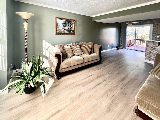 living room with ceiling fan, ornamental molding, a textured ceiling, and hardwood / wood-style flooring