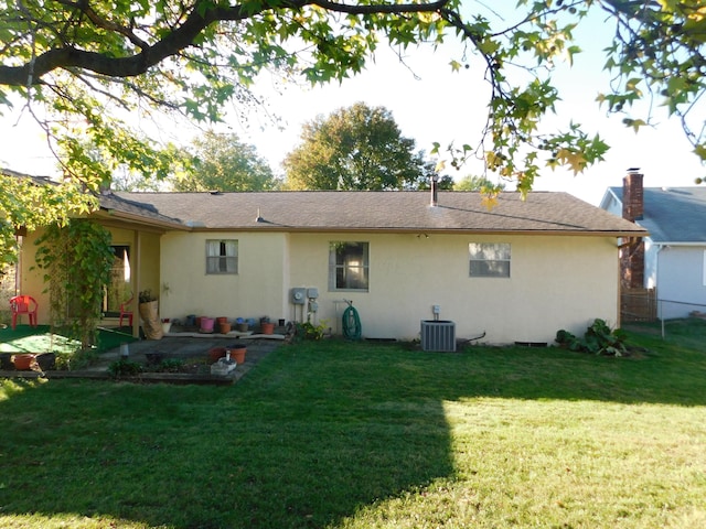 back of property featuring a lawn and central air condition unit