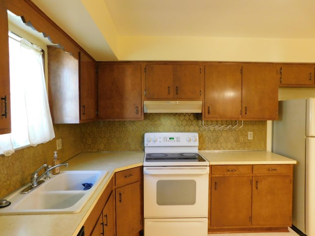 kitchen with white appliances, backsplash, and sink