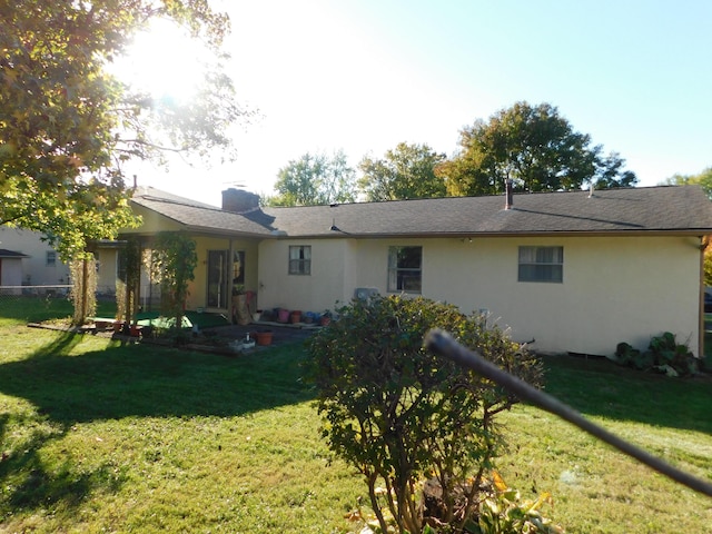 rear view of house featuring a lawn