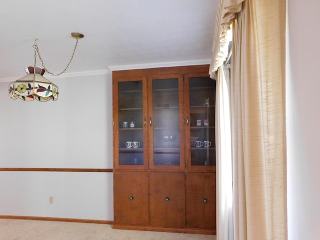 unfurnished dining area featuring light carpet and crown molding