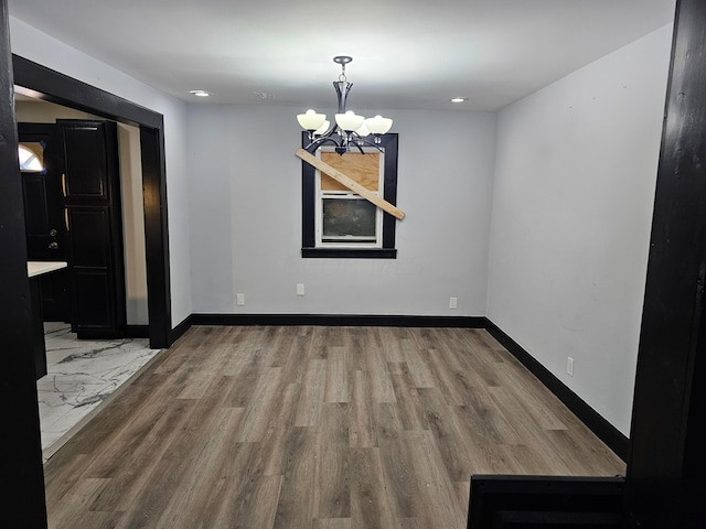 unfurnished dining area with light hardwood / wood-style floors and a notable chandelier